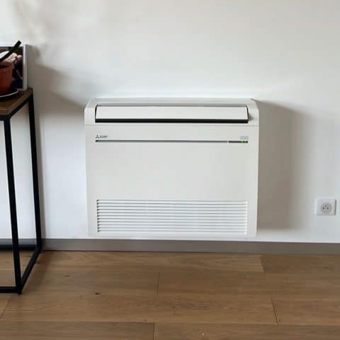 Climatiseur Console Mitsubishi Blanc pour Salon Moderne Climatiseur console Mitsubishi blanc fixé au mur au-dessus d'un parquet en bois dans un intérieur épuré.